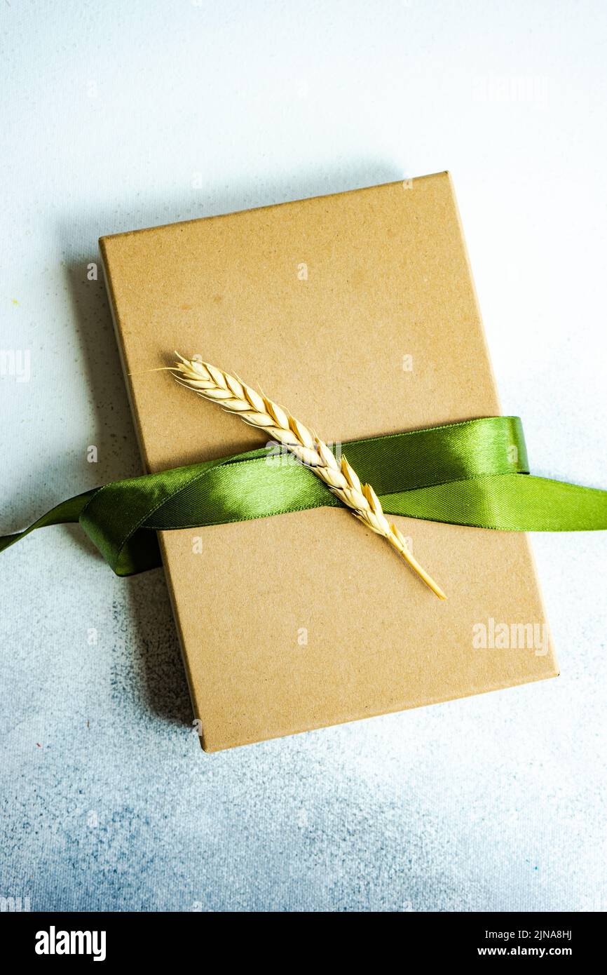 Caja de regalo con cinta verde brillante sobre fondo de hormigón Foto de stock