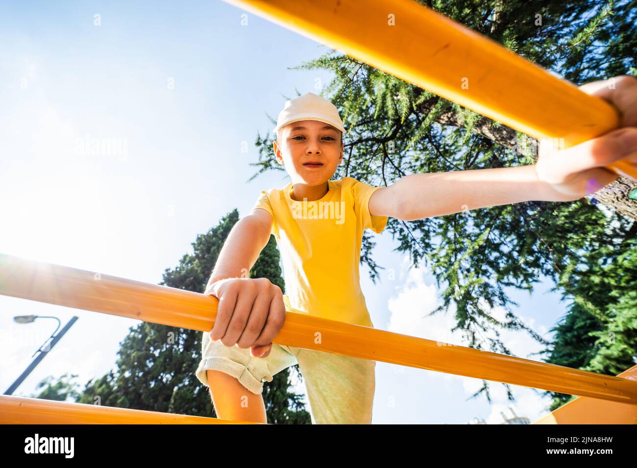 Niño sonriente en el parque de juegos en un día soleado Foto de stock