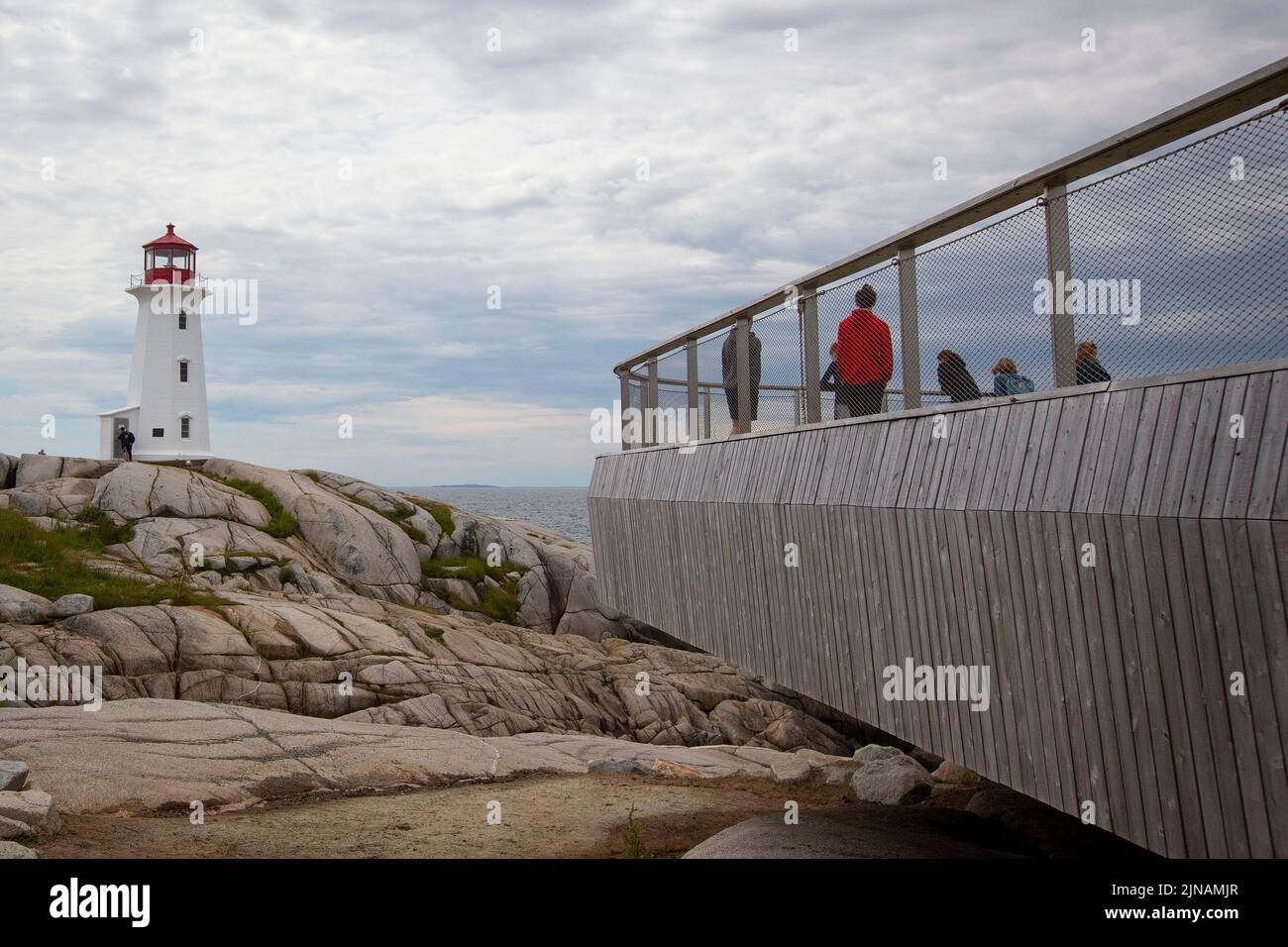 La gente camina alrededor del faro de Peggy's Cove en Peggy's Cove, Nueva Escocia el viernes 8 de julio de 2022. Foto de stock