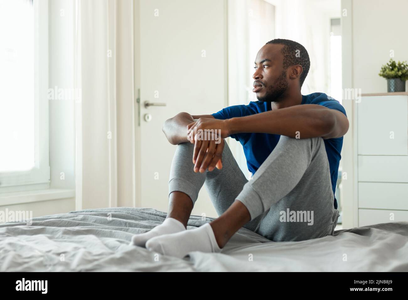 Hombre Afroamericano Pensando en Problemas Teniendo Depresión En Dormitorio Foto de stock
