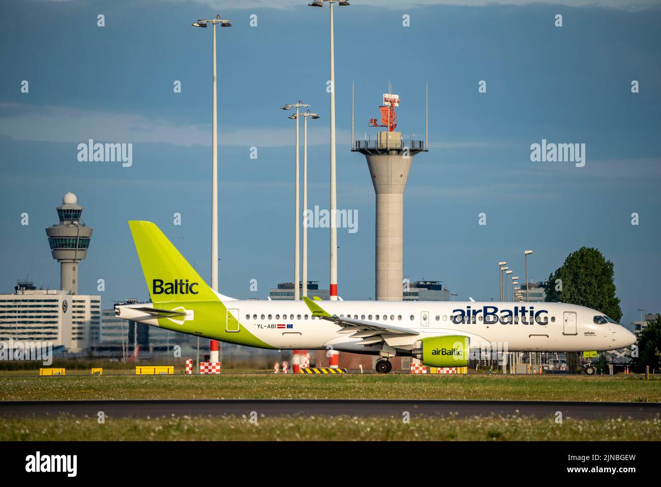 Amsterdam Shiphol Airport, Polderbaan, una de las 6 pistas de aterrizaje, torre de control de tráfico aéreo, en la vía de taxi para el despegue, YL-abi, Air Baltic Airbus A220-300. Foto de stock