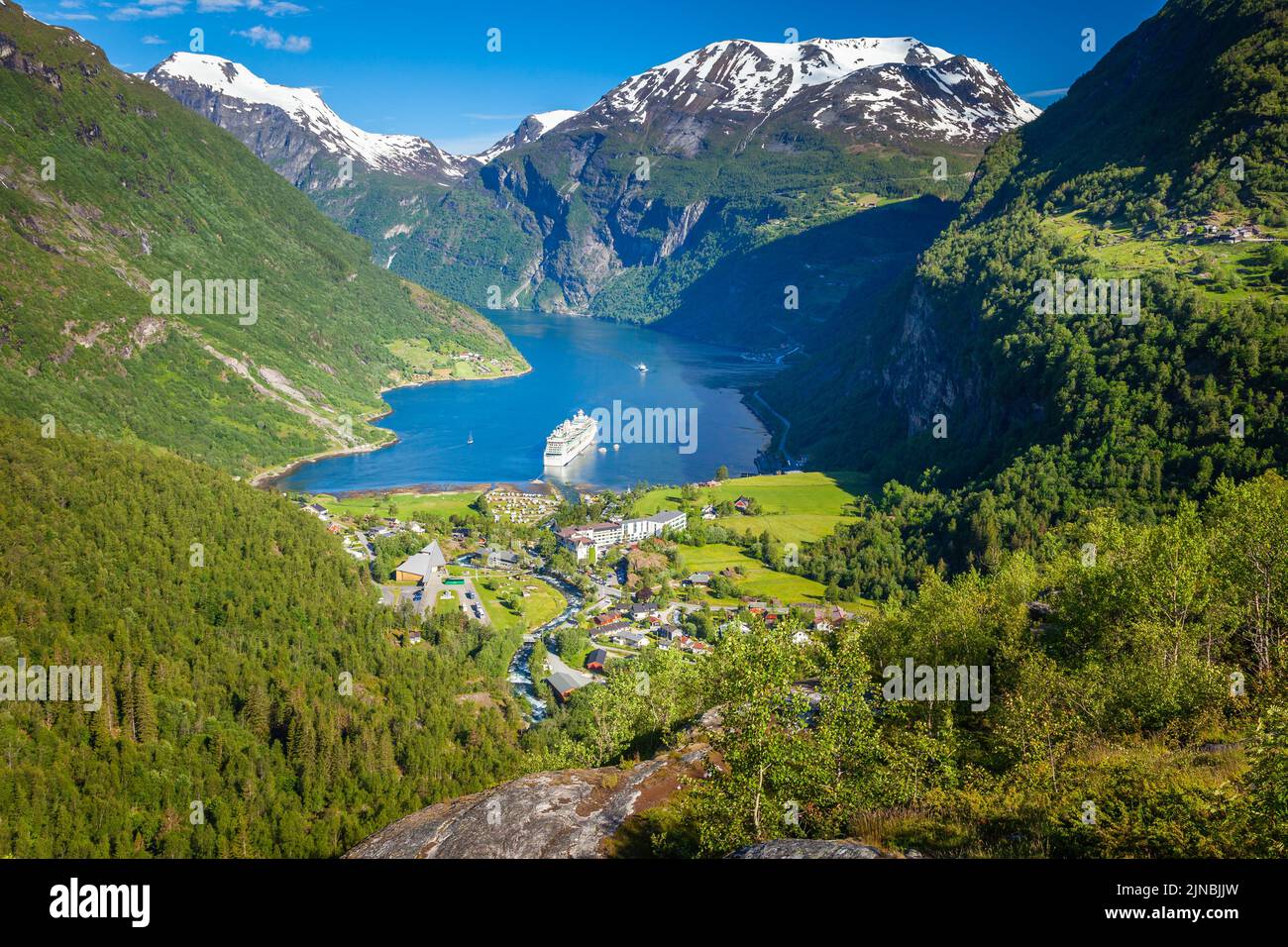 Sobre el fiordo Geiranger, barco y pueblo, Noruega, norte de Europa Foto de stock