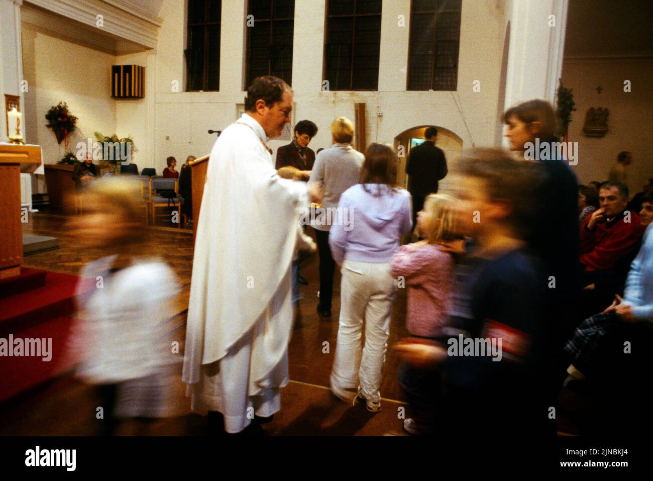 Congregación saliendo después de la Misa en Nochebuena St Cecilia's Cheam Surrey Inglaterra Foto de stock