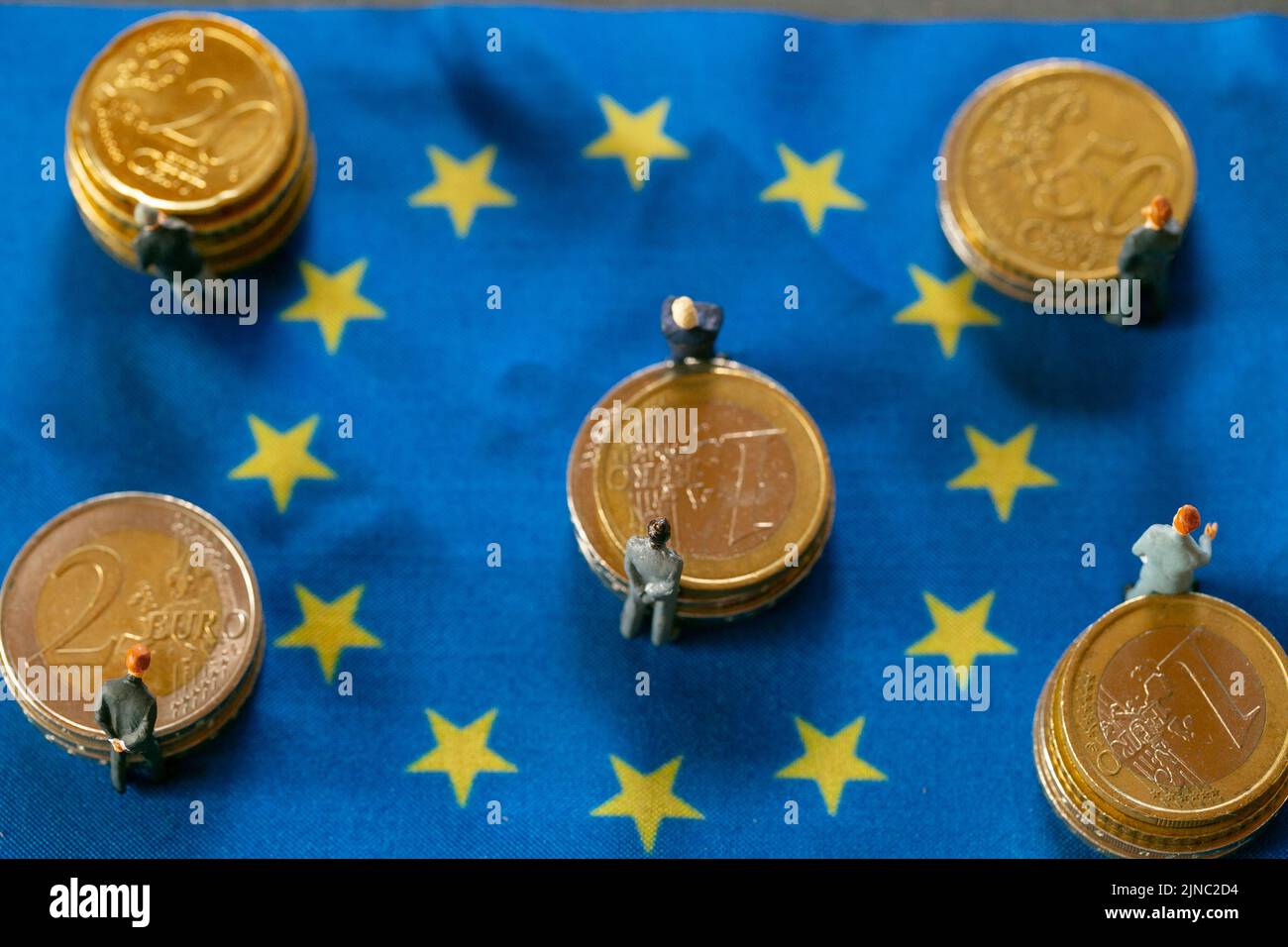 Economía en países europeos. Figuras de hombres en trajes en monedas de euro en banderas de la Unión europea. La élite económica y política de Europa. Presupuestos y. Foto de stock