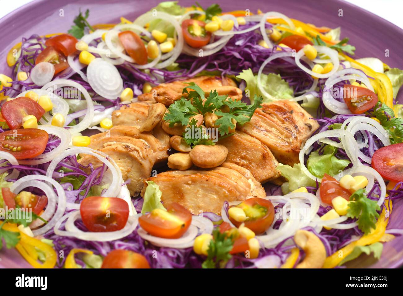 Pan pollo frito con verduras y primer plano en plato púrpura Foto de stock