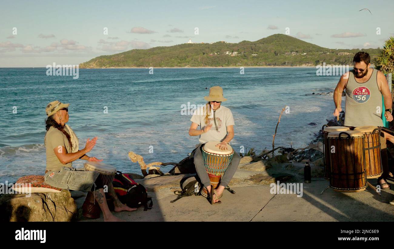 BYRON BAY, AUSTRALIA - NOV 3 2021: Tres miembros de un grupo africano de tambores en la playa principal de nueva gales del sur Foto de stock