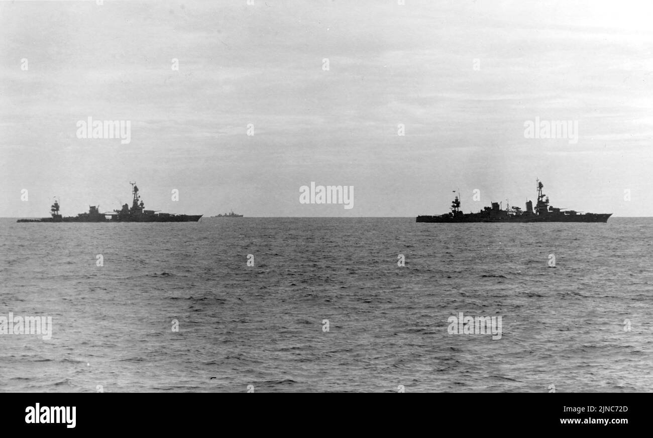 El USS Louisville (derecha) lanza el lisiado Chicago en la mañana del 30 de enero de 1943. El USS Chicago fue golpeado por un torpedo durante la Batalla de Rennell Island el 30 de enero de 1943. El Chicago fue atacado de nuevo mientras era remolcado y fue hundido. Foto de stock