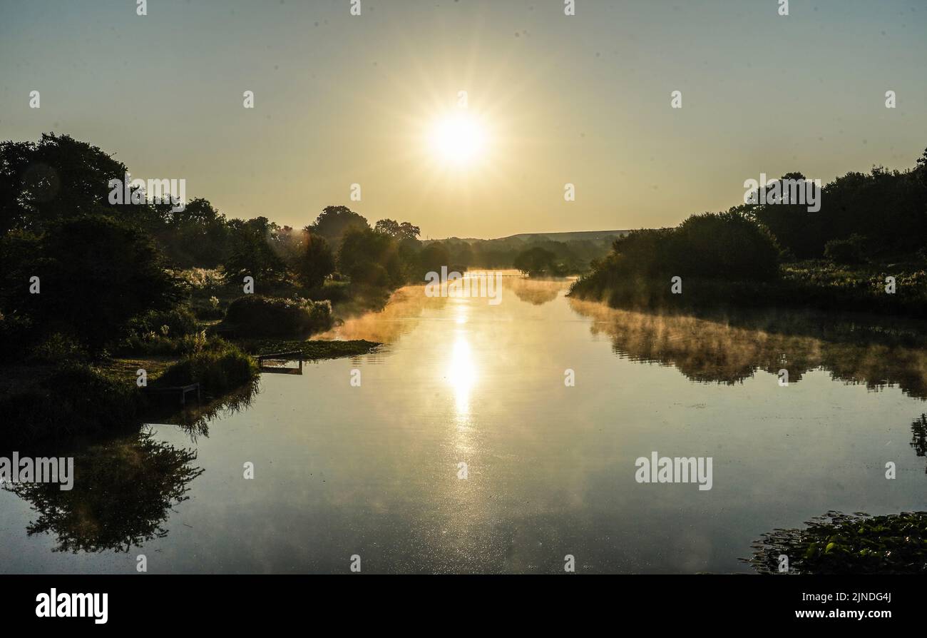 El sol sale sobre Berwick Pond en Rainham, Essex. Fecha de la foto: Jueves 11 de agosto de 2022. Foto de stock