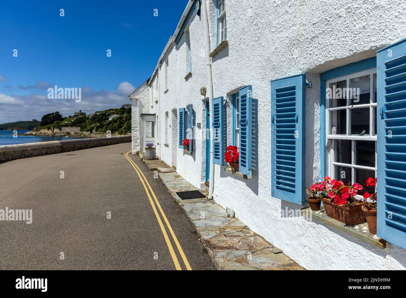 Contraventanas azules en las ventanas de las antiguas casas de pescadores frente al mar en St Mawes, Cornwall, Inglaterra. Foto de stock
