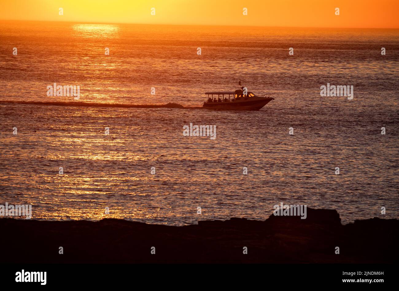 Los barcos de recreo llevan a la gente a ver la puesta de sol en Godrevy, Cornwall, Reino Unido Foto de stock