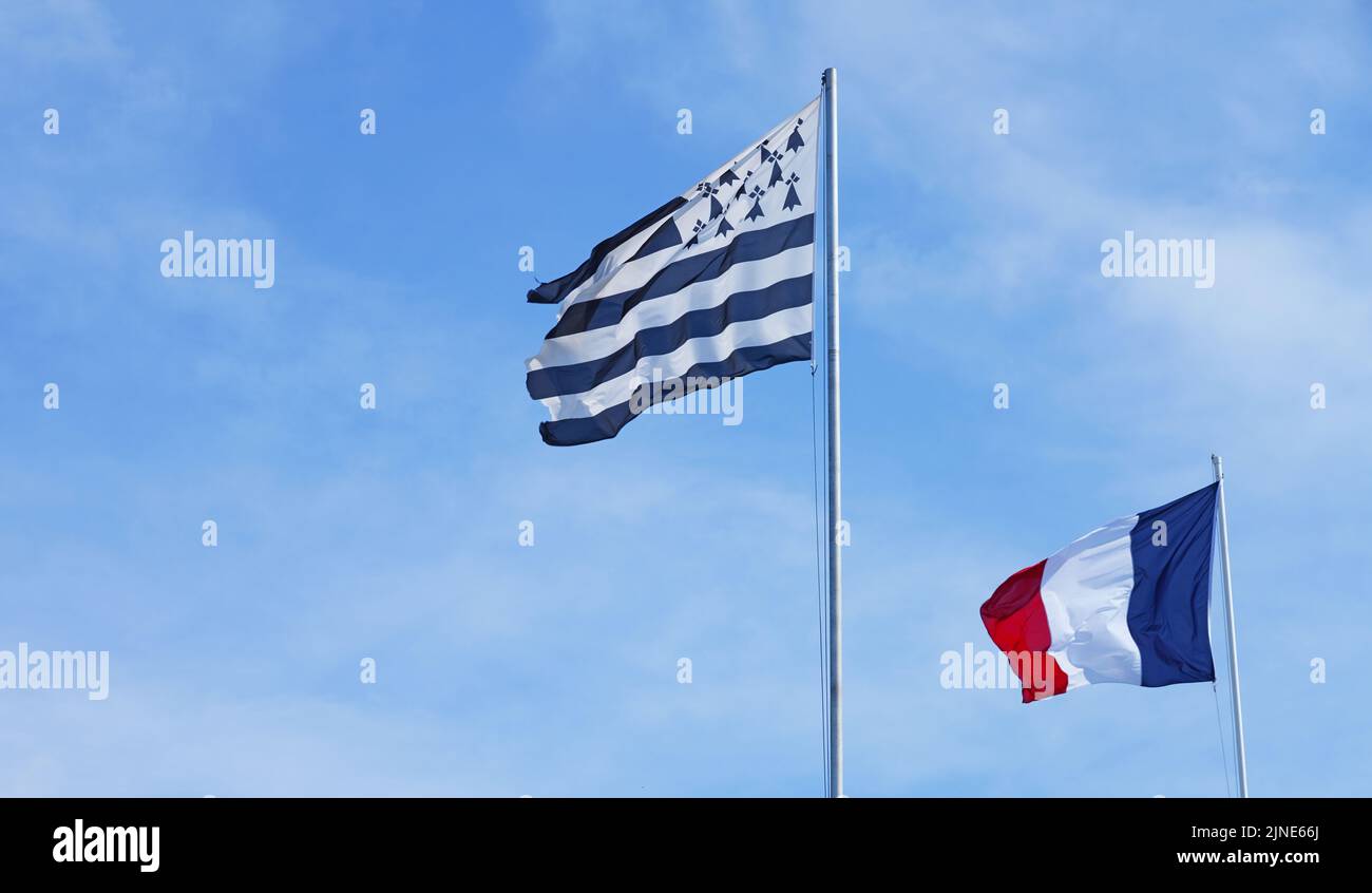 Vista de la bandera francesa y la bandera bretona volando lado a lado en Bretaña, Francia Foto de stock