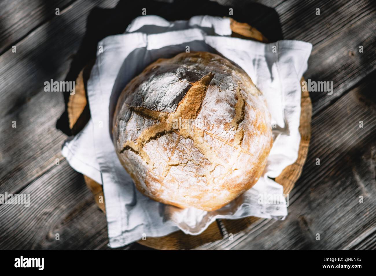Pan de masa fermentada tradicional con piel de regadura en una mesa rústica de madera. Fotografía de alimentos saludables Foto de stock