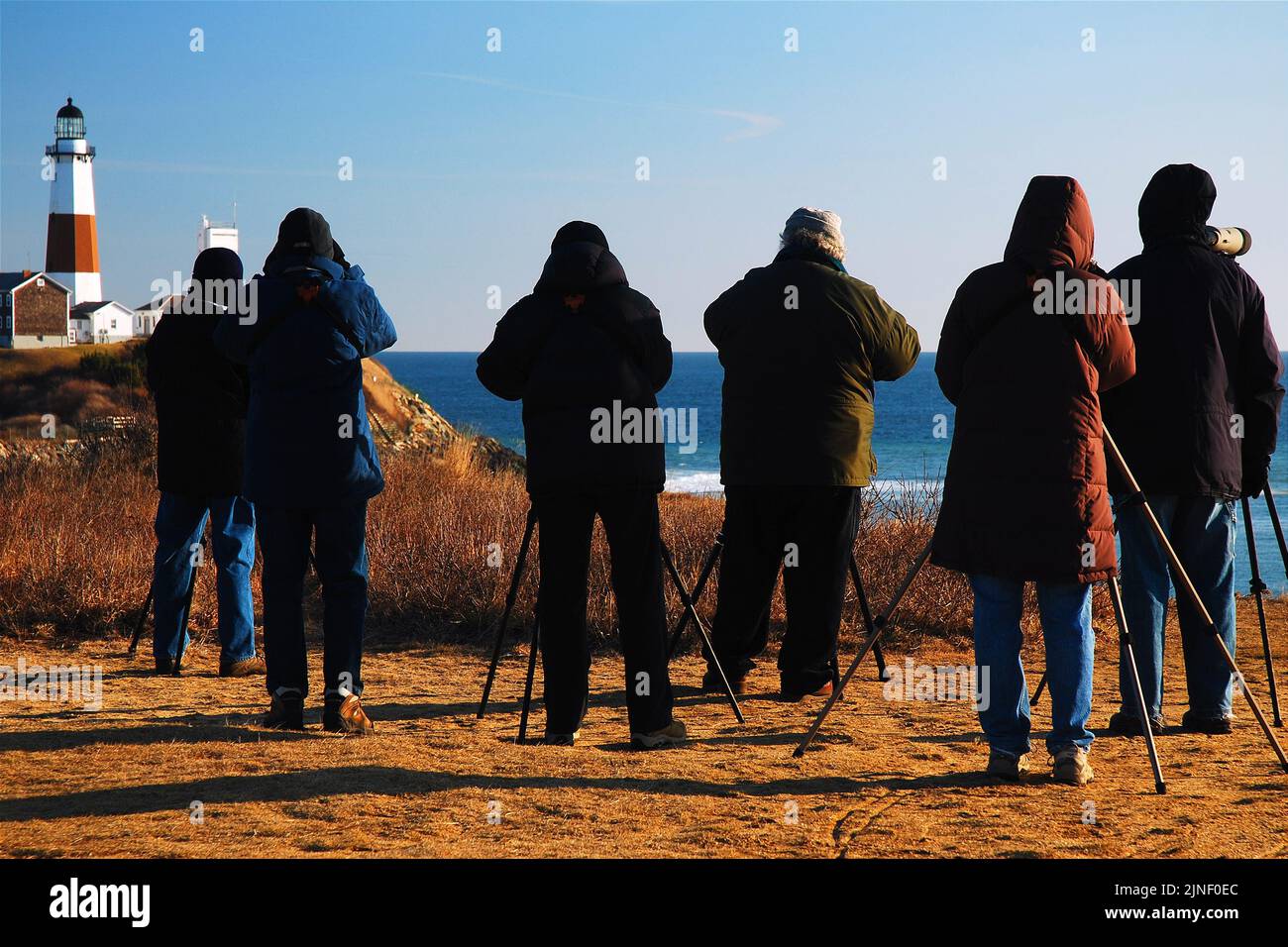Un grupo de observadores de aves se reúnen en Montauk Point, cerca del faro en el extremo oriental de Long Island en un día de invierno para observar la vida silvestre Foto de stock