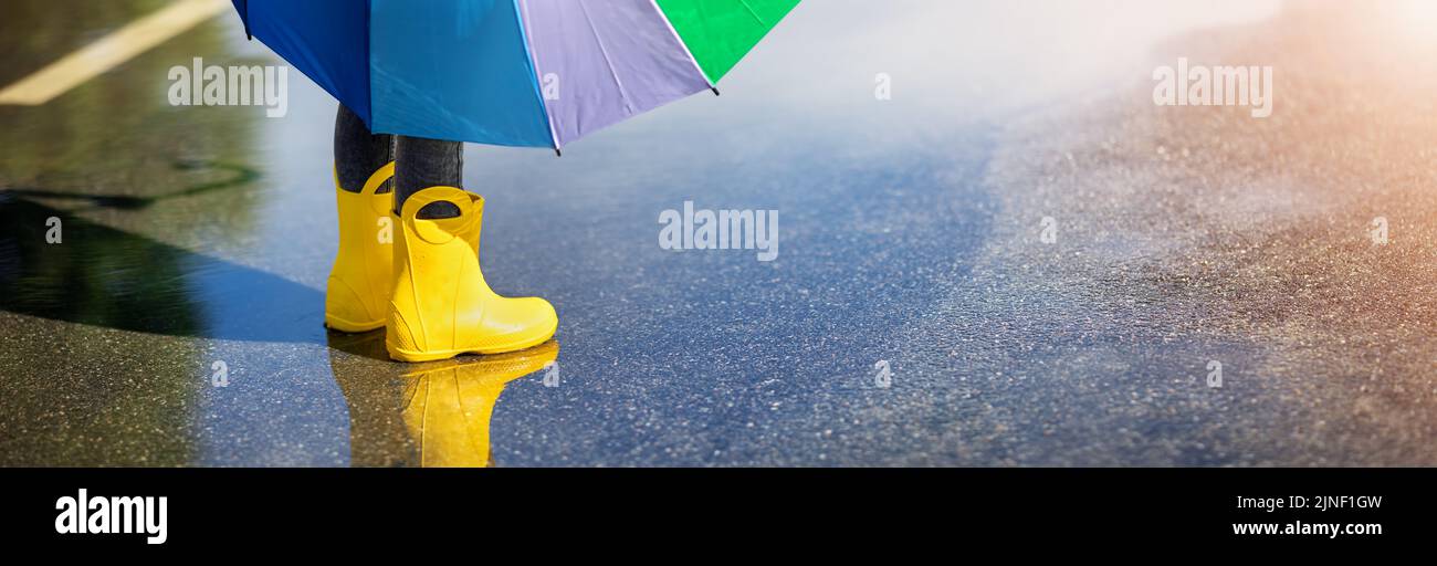 Mujer joven con chubasquero amarillo y botas de goma en la naturaleza  primaveral Fotografía de stock - Alamy