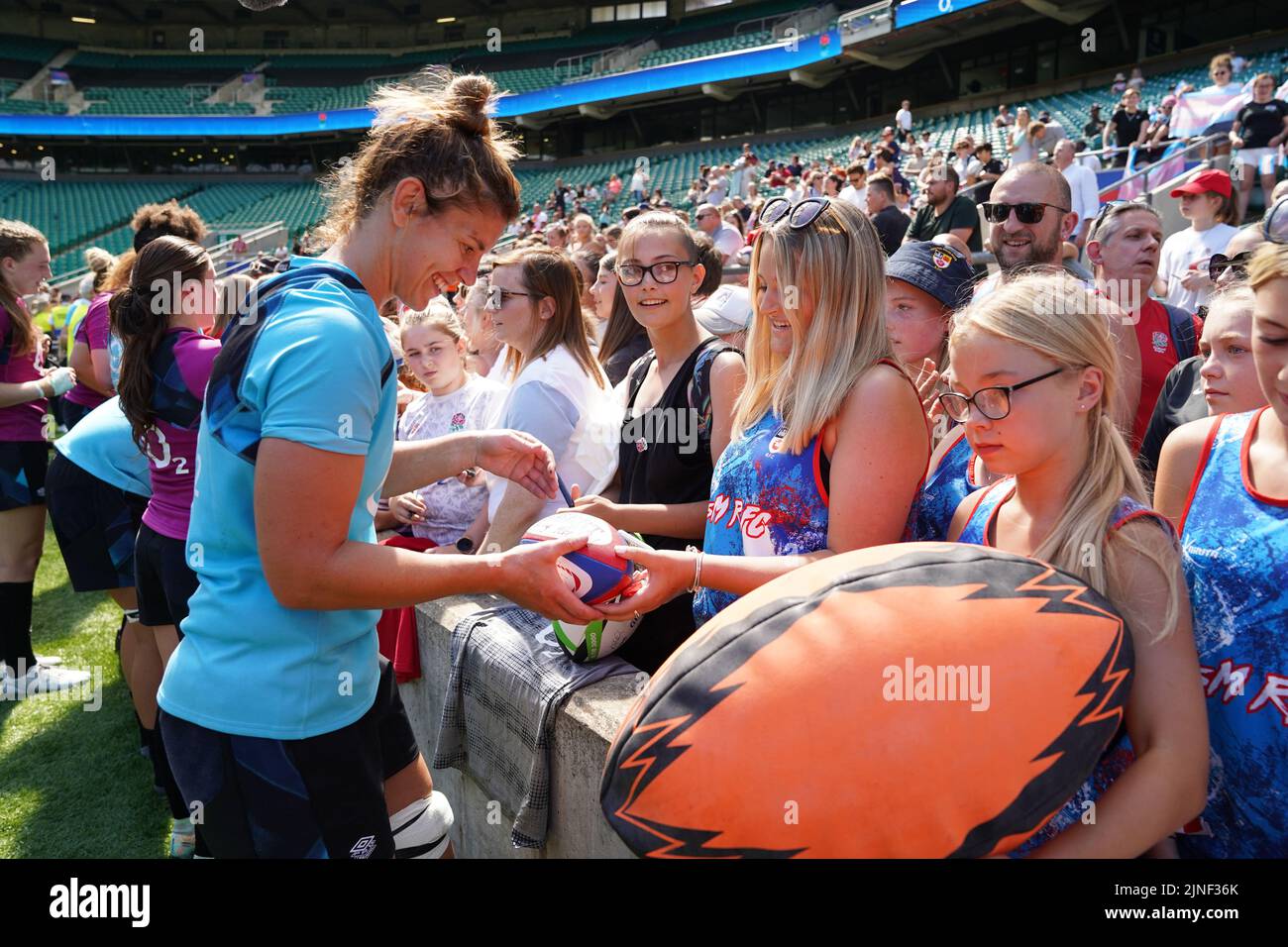 Sarah Hunter, de Inglaterra, firma un autógrafo para un fan después de una sesión de entrenamiento abierta en el Twickenham Stadium, Londres. Fecha de la foto: Jueves 11 de agosto de 2022. Foto de stock