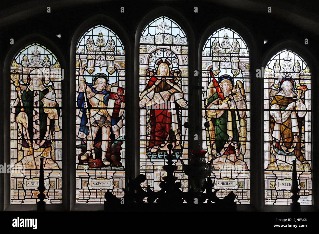 Vitral por Percy Bacon & Brothers representando a Cristo Consoler, y los Santos Nicolás, George, Michael & Luke, All Saints Church, Northampton, Foto de stock