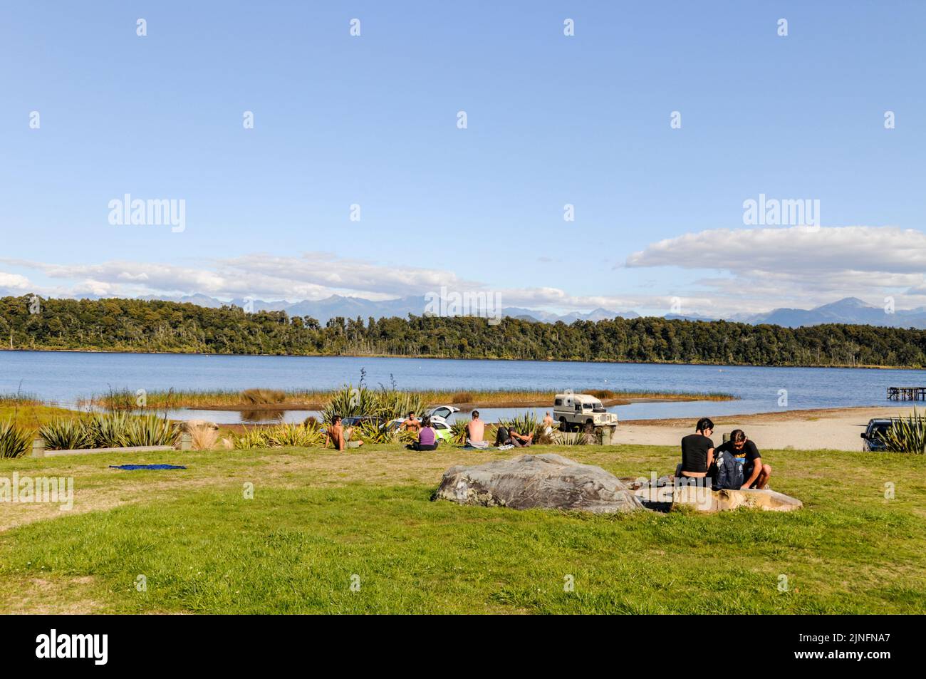 Los visitantes se relajan en la bahía de Shanghai en la reserva escénica del lago Mahinapua en Ruatapu cerca de Hokitika en la costa oeste de la isla del sur de Nueva Zelanda. Foto de stock