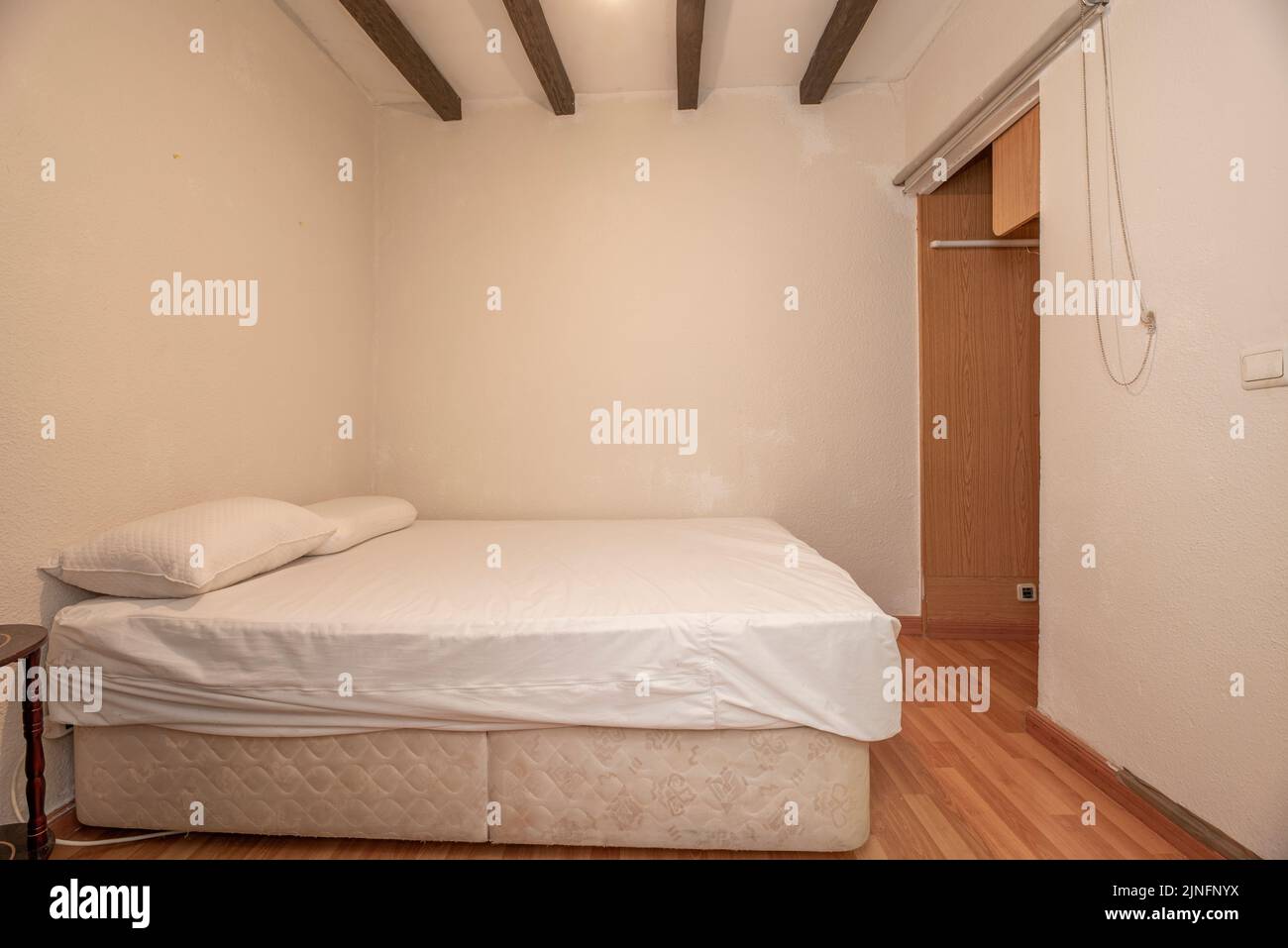 Pequeña habitación con vigas vistas, cama de matrimonio con cama nido y  suelo de madera Fotografía de stock - Alamy