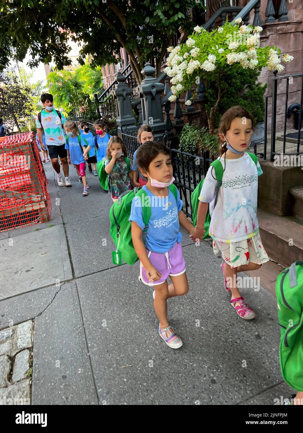 Campamento de día Los niños en Park Slope, Brooklyn caminan juntos en parejas hacia Prospect Park en un día de verano en Brooklyn, Nueva York. Foto de stock