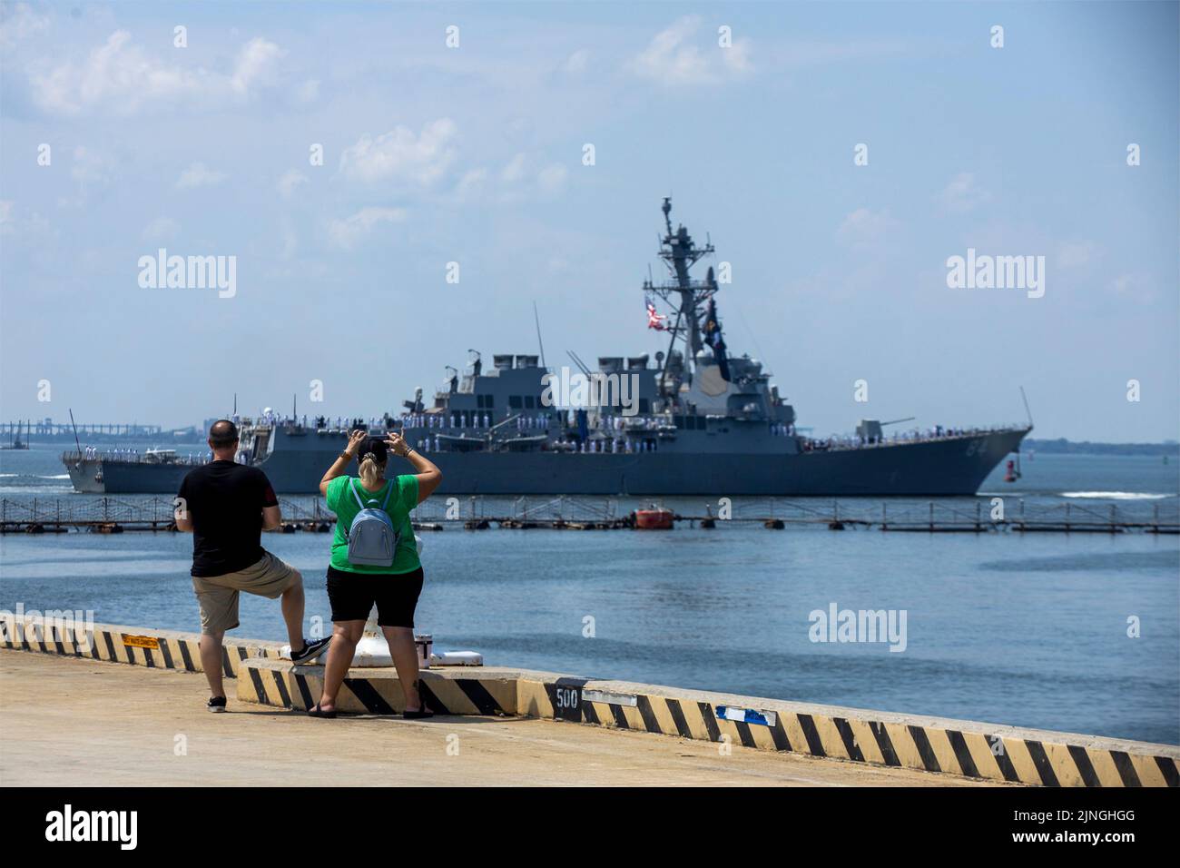 Los miembros de la familia observan como el destructor de misiles guiados clase Arleigh Burke USS Bulkeley de la Armada de los EE.UU. Sale de la Estación Naval Norfolk durante las operaciones rutinarias, el 4 de agosto de 2022 en Norfork, Virginia. Foto de stock