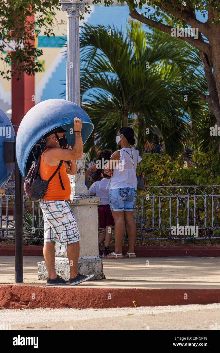 TRINIDAD, CUBA - ENERO de 6 2021: Hombre hablando por teléfono en una cabina telefónica en Trinidad, Cuba Foto de stock
