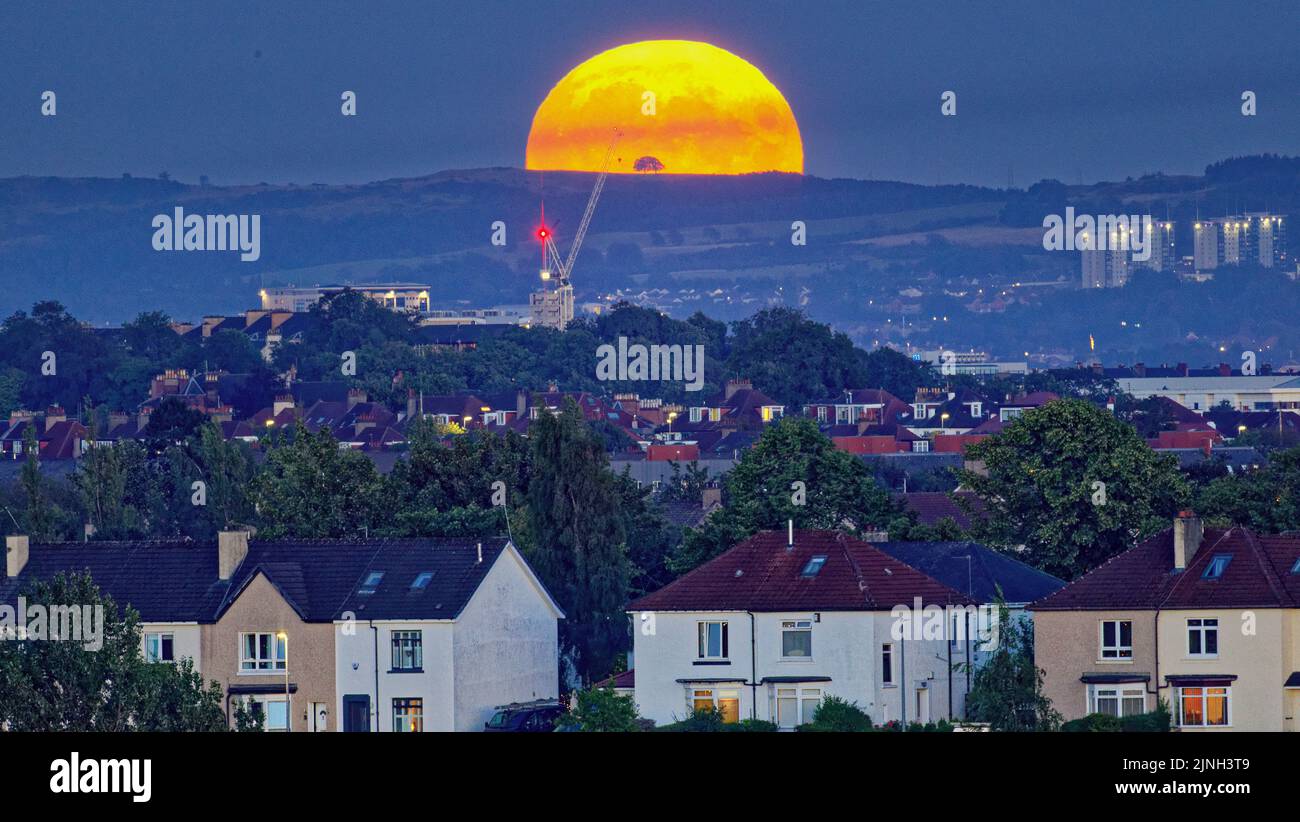 Glasgow, Escocia, Reino Unido 11th de agosto de 2022. Tiempo en Reino Unido: El tiempo soleado vio la luna llena de esturión sobre el suroeste de la ciudad y las colinas de los campings braes. Crédito Gerard Ferry/Alamy Live News Foto de stock