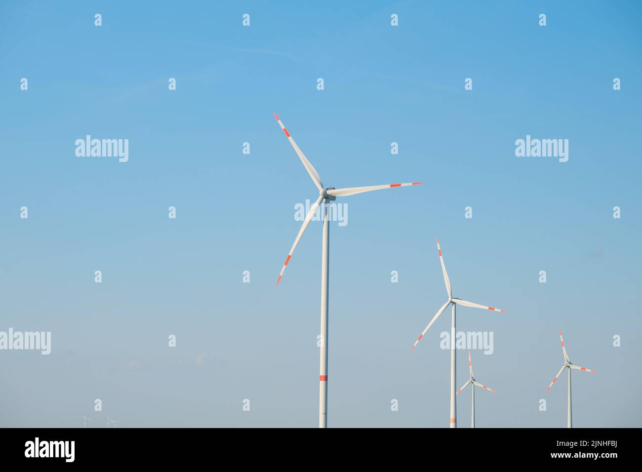 Wind renovable energy. Molinos de viento en un fondo azul cielo. Generadores de viento. Fuentes de energía alternativas. Foto de stock