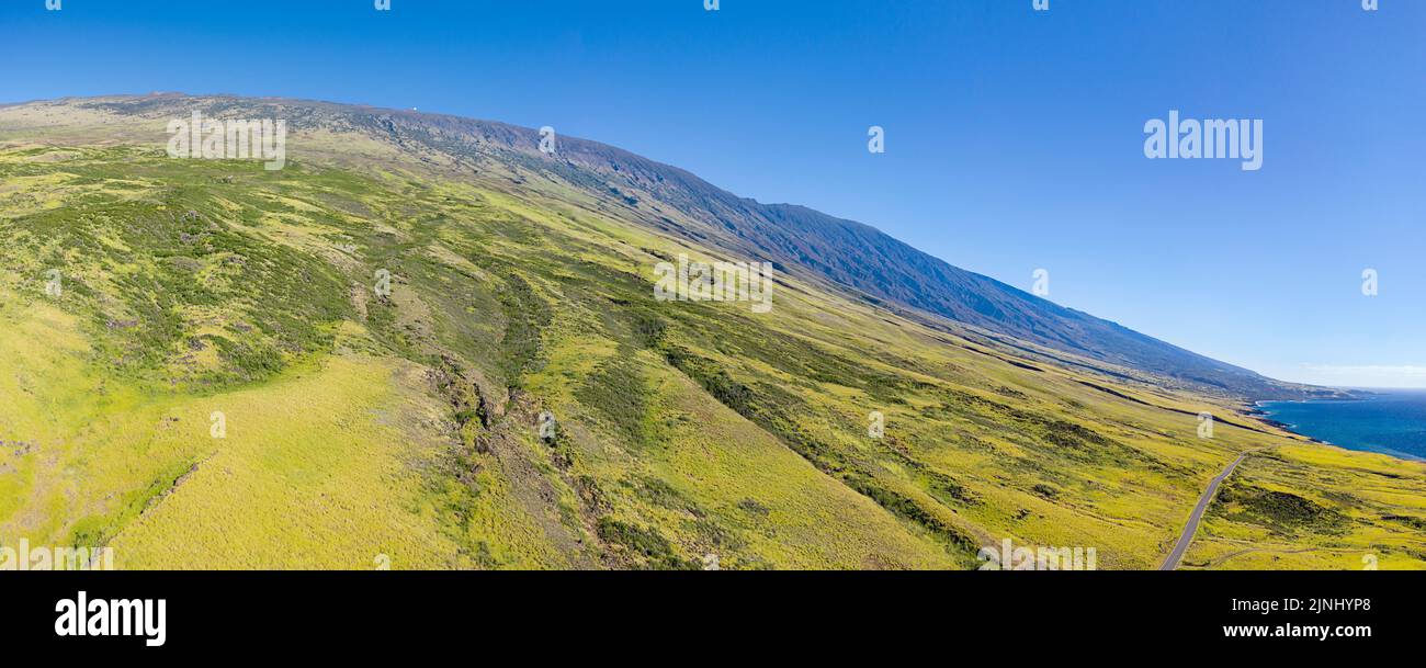 Vista aérea panorámica compuesta de tierras de pastos que cubren las laderas meridionales de la montaña Haleakala en el sudeste de Maui; con observatorio visible, Hawai Foto de stock