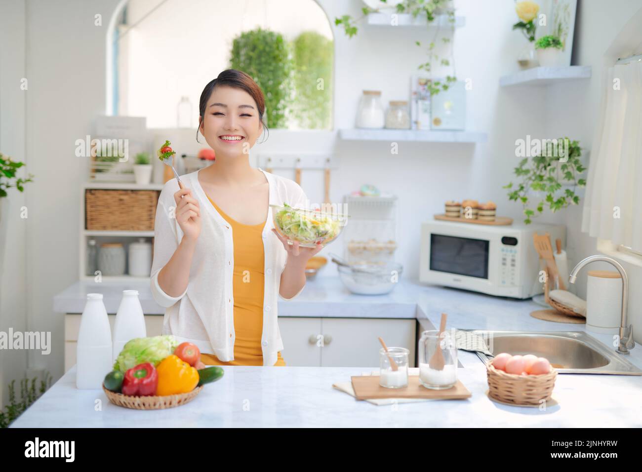 Pretty Woman comer una ensalada en la cocina Foto de stock