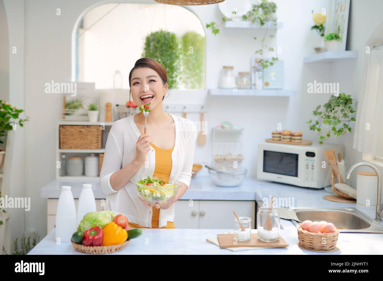 Close Up retrato de linda chica comer ensalada en la cocina Foto de stock