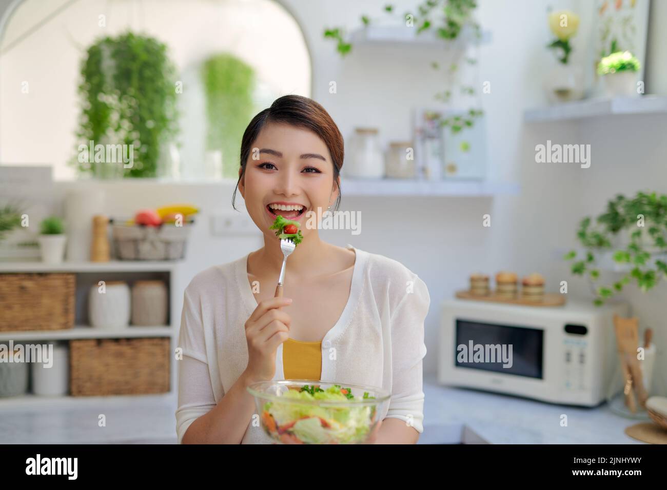 Hermosa niña con un plato de ensalada de vitaminas frescas de verduras Foto de stock