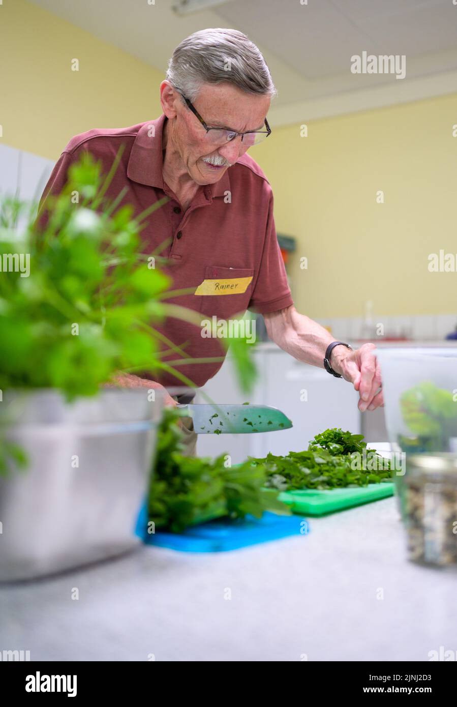 PRODUCCIÓN - 30 de junio de 2022, Baja Sajonia, Lüneburg: El participante Rainer prepara ensalada en el grupo de cocina para los viudos que se afligen. Los miembros del pequeño grupo, que se reúne una vez al mes en Lüneburg para cocinar, tienen entre 59 y 87 años. Un profesional guía a los viudos. (A dpa-KORR 'Grupo de cocina para viudos afligidos - las comidas listas son tabú') Foto: Philipp Schulze/dpa Foto de stock