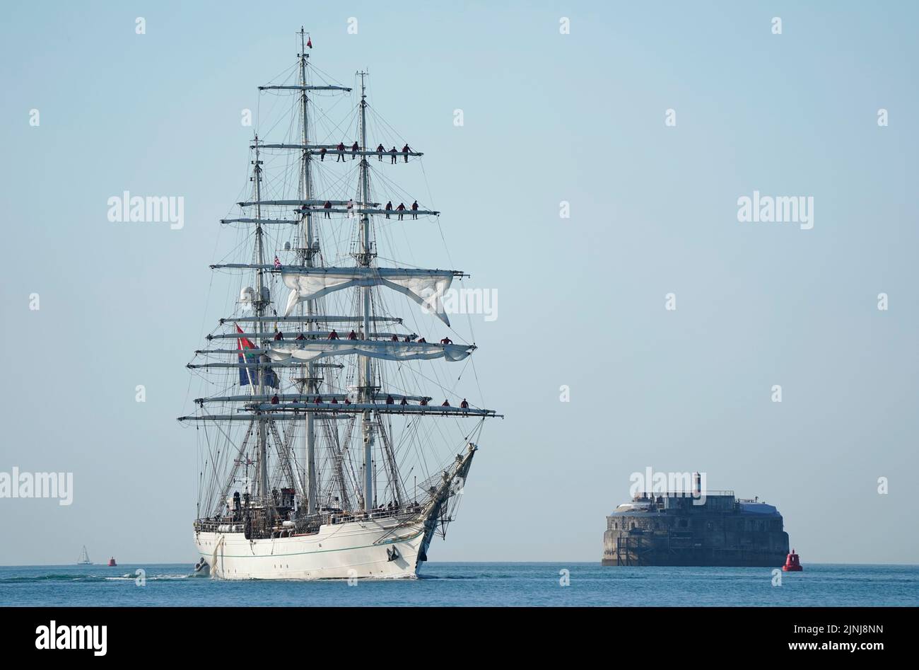 El buque Shabab Oman II, un buque de entrenamiento de la Royal Navy de Omán, pasa por el fuerte Spitbank mientras KIT llega al puerto de Portsmouth. El barco es una mezcla de lo tradicional y lo moderno con sistemas de comunicación informatizados y equipos de navegación de vanguardia, pero desde la plataforma de madera hacia arriba, el barco es tradicional en términos de velas y aparejo. Fecha de la foto: Viernes 12 de agosto de 2022. Foto de stock