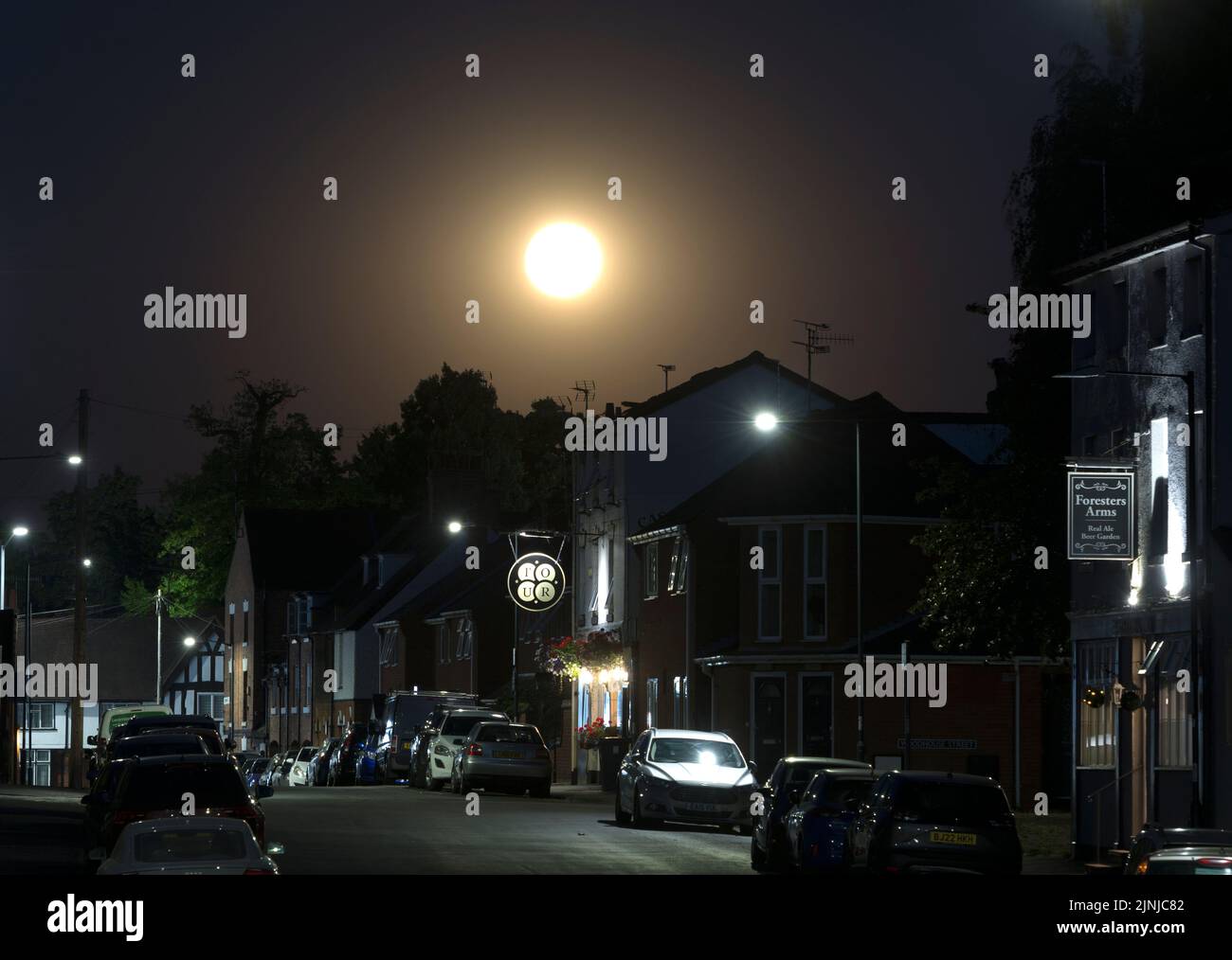 Una luna llena que se eleva sobre Crompton Street, Warwick, Warwickshire, Reino Unido Foto de stock