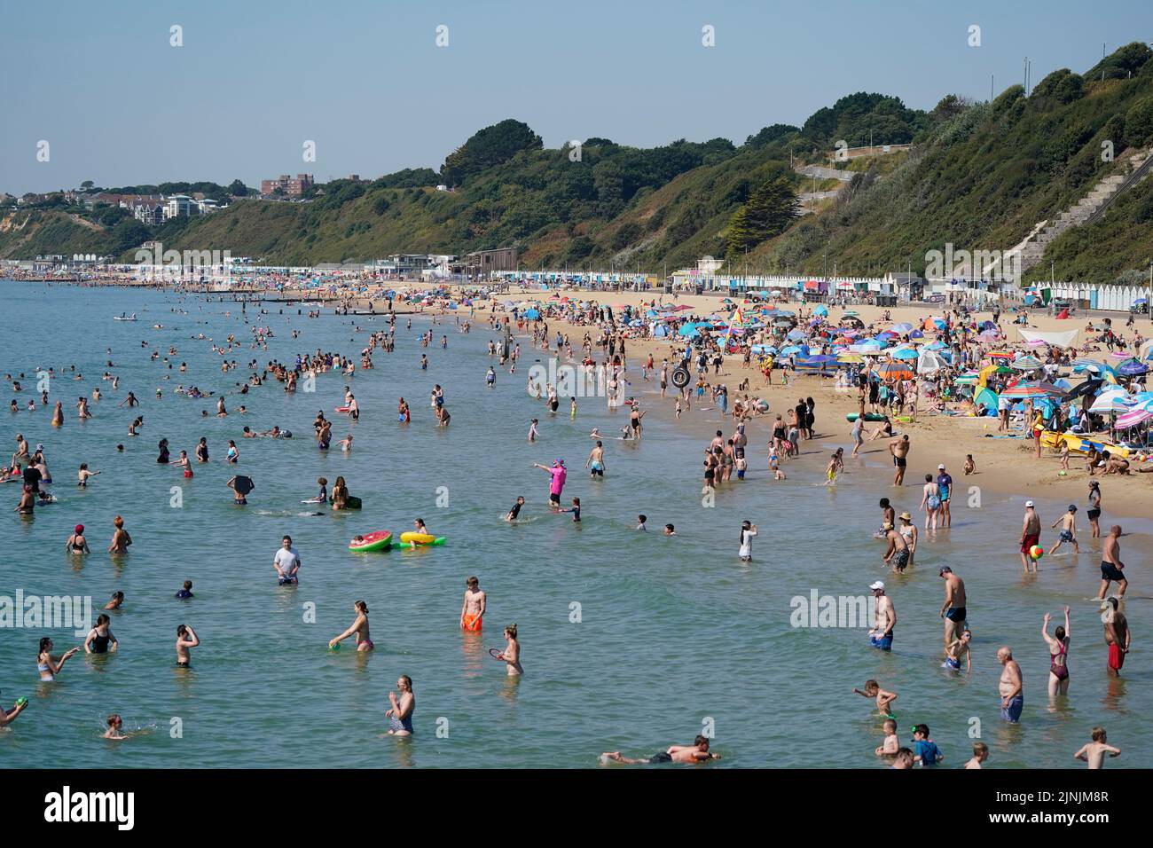 La gente disfruta del calor en la playa de Bournemouth, Dorset. Está previsto que se declare una sequía en algunas partes de Inglaterra el viernes, con temperaturas que alcanzarán los 35C grados, lo que hace que el país sea más caliente que algunas partes del Caribe. Fecha de la foto: Viernes 12 de agosto de 2022. Foto de stock