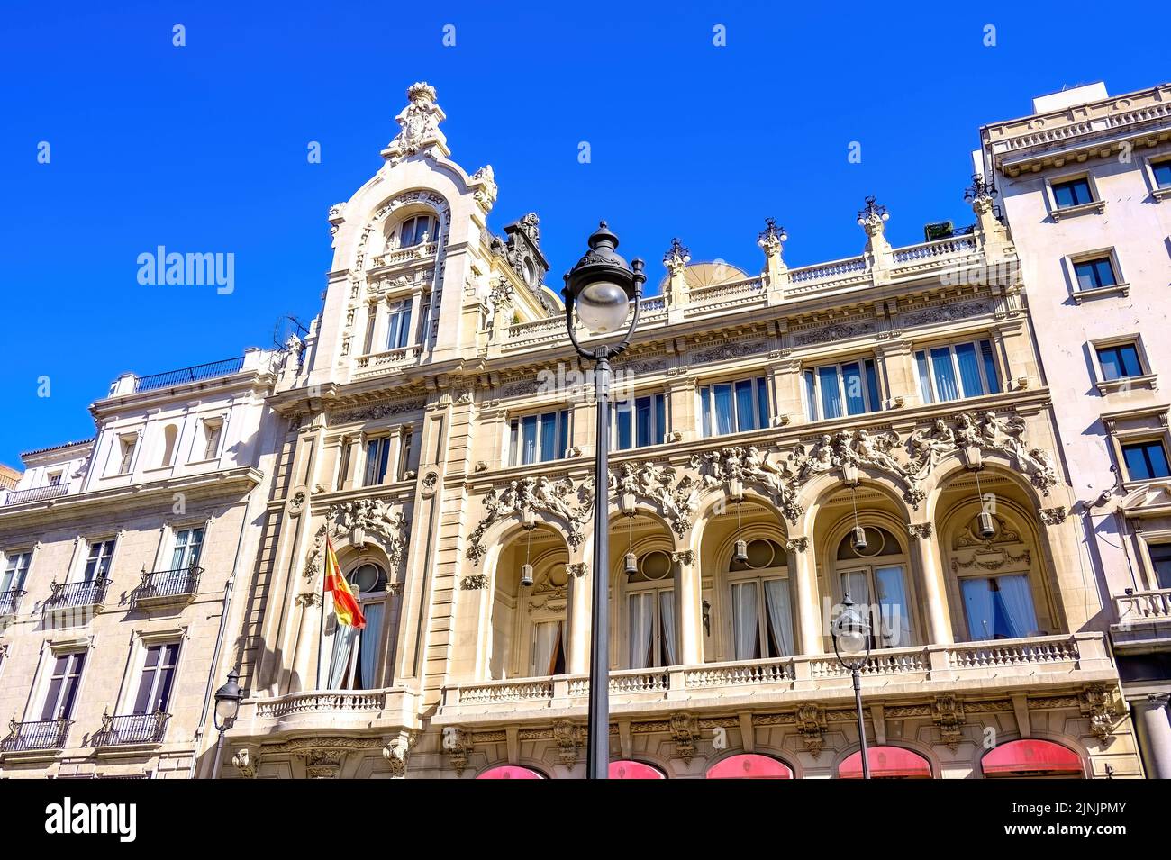 Arquitectura exterior del Casino de Madrid. Vista lateral de la fachada enmarcada en una farola. En 1993, fue declarada Propiedad Española de Cultura Foto de stock