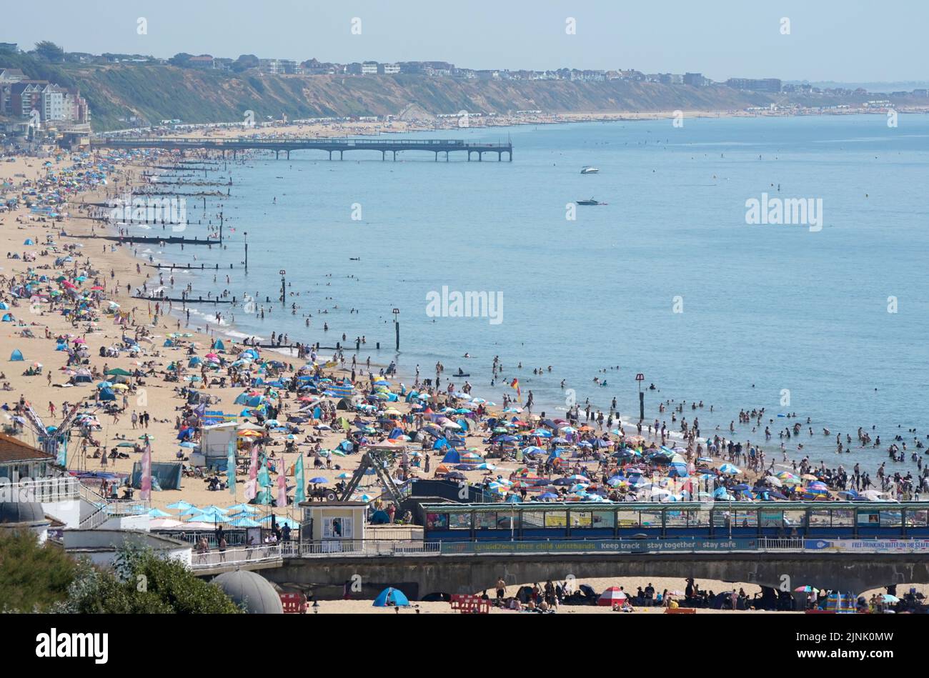 La gente se reúne en el calor de la playa de Bournemouth en Dorset. Está previsto que se declare una sequía en algunas partes de Inglaterra el viernes, con temperaturas que alcanzarán los 35C grados, lo que hace que el país sea más caliente que algunas partes del Caribe. Fecha de la foto: Viernes 12 de agosto de 2022. Foto de stock