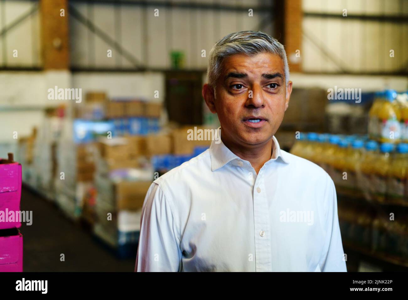 El alcalde de Londres, Sadiq Khan, habla con los medios de comunicación durante una visita al centro de almacenes Newham Food Alliance en North Woolwich. El centro, que es dirigido por el consejo Newham, recoge los alimentos y luego los entrega a los bancos de alimentos en todo el municipio.Fecha de la foto: Viernes 12 de agosto de 2022. Foto de stock