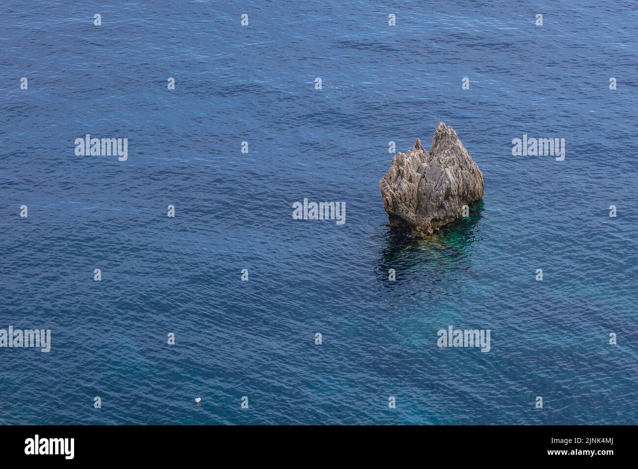 Afloramiento rocoso visto desde la orilla en Palaiokastritsa famoso complejo turístico en la isla griega de Corfú Foto de stock