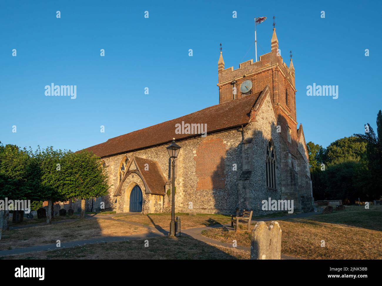 All Saints Church en Odiham Village, Hampshire, Inglaterra, Reino Unido, un edificio catalogado de grado I, en una soleada noche de verano Foto de stock