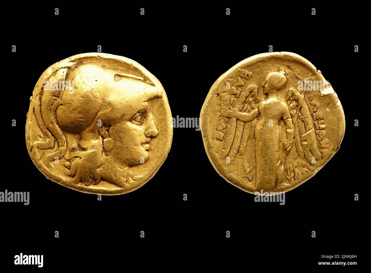 Dos caras de una antigua moneda de oro griega con Alejandro Magno aislado sobre fondo negro. Foto de stock
