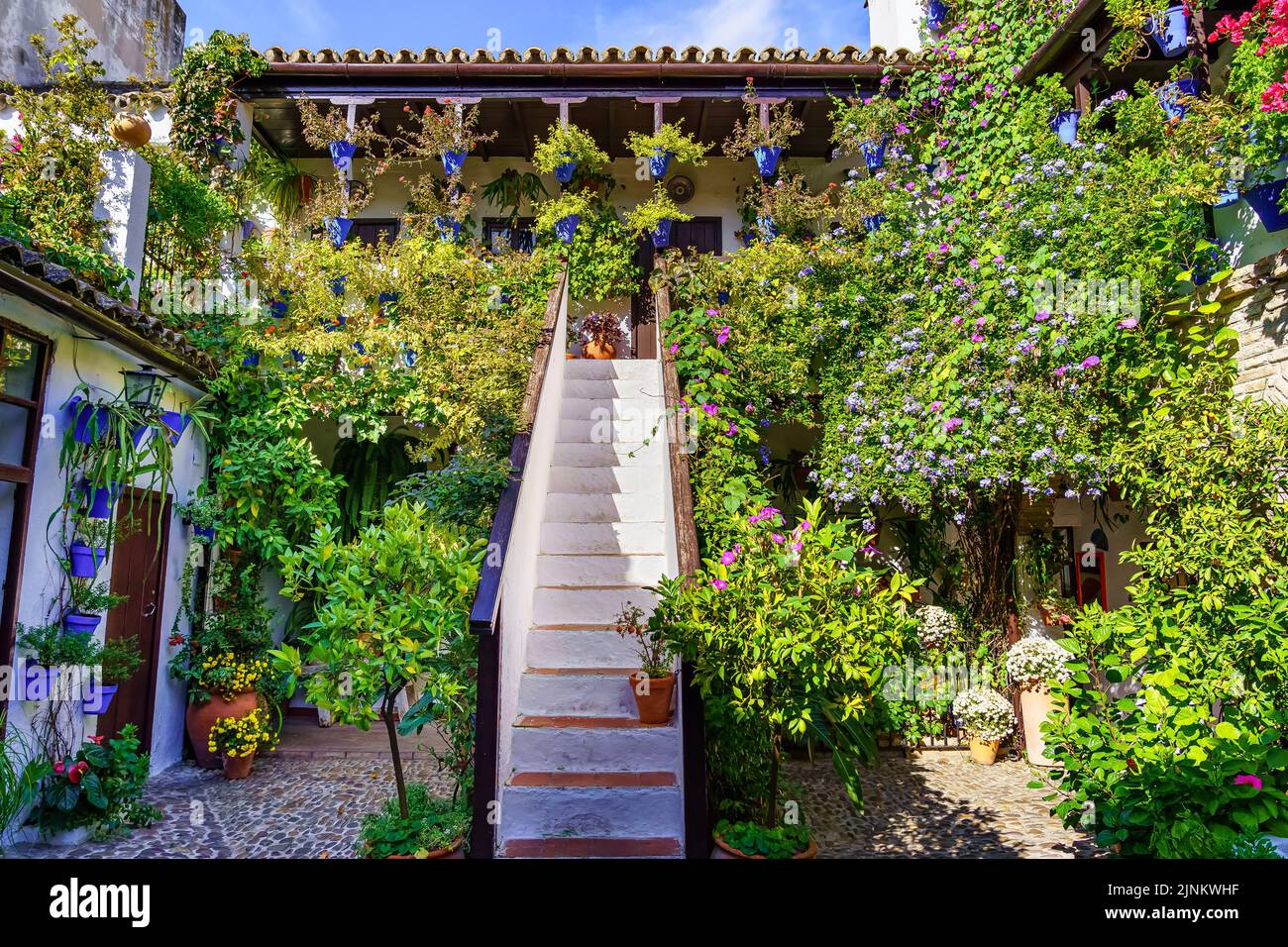 Típico patio andaluz en Córdoba con plantas, flores y escaleras a la