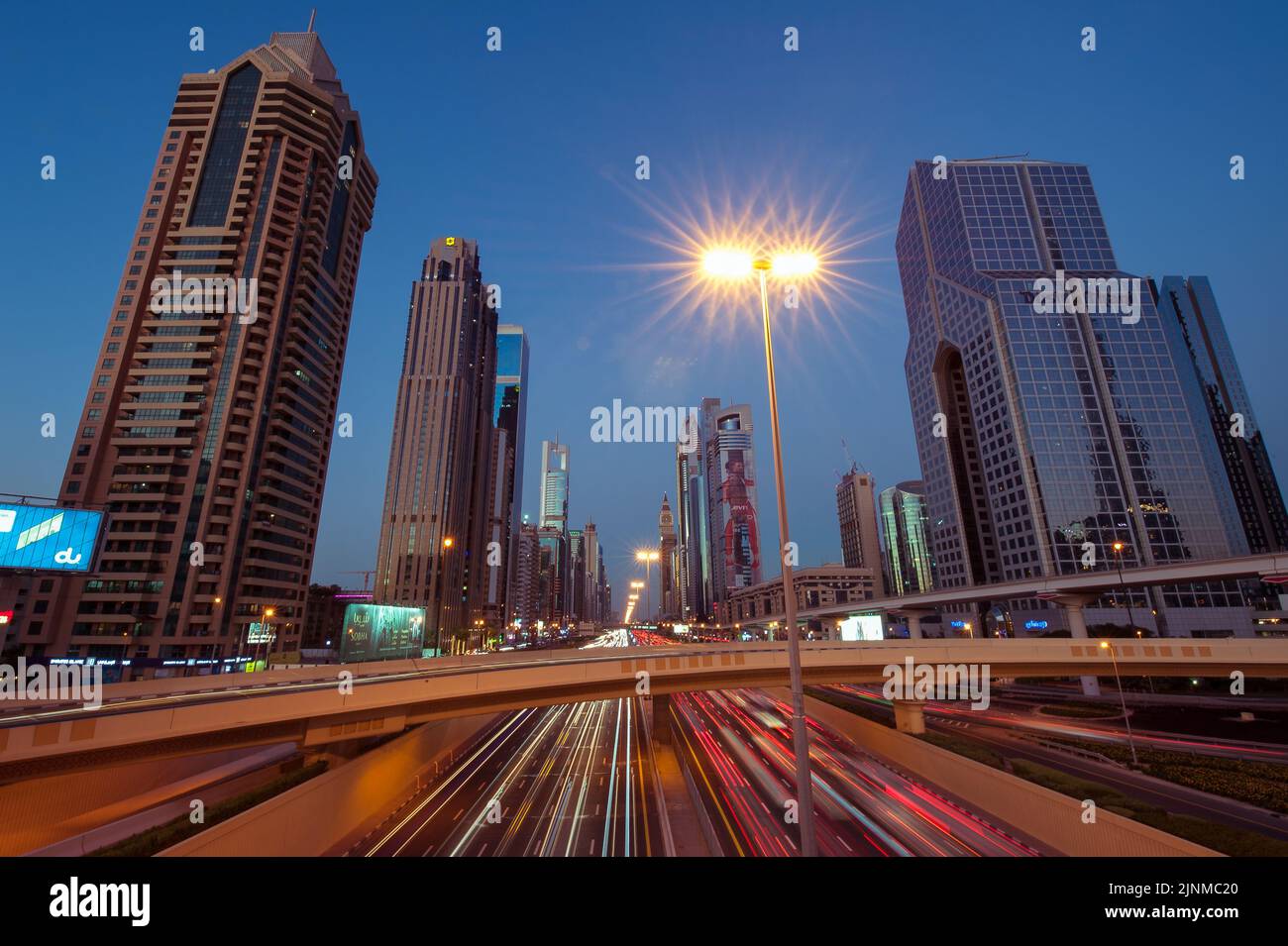 Amplia imagen del tráfico y los edificios a lo largo de Sheikh Zayed Road, la autopista más larga de Dubai y de todos los Emiratos Árabes Unidos. Paisaje urbano por la noche. Foto de stock