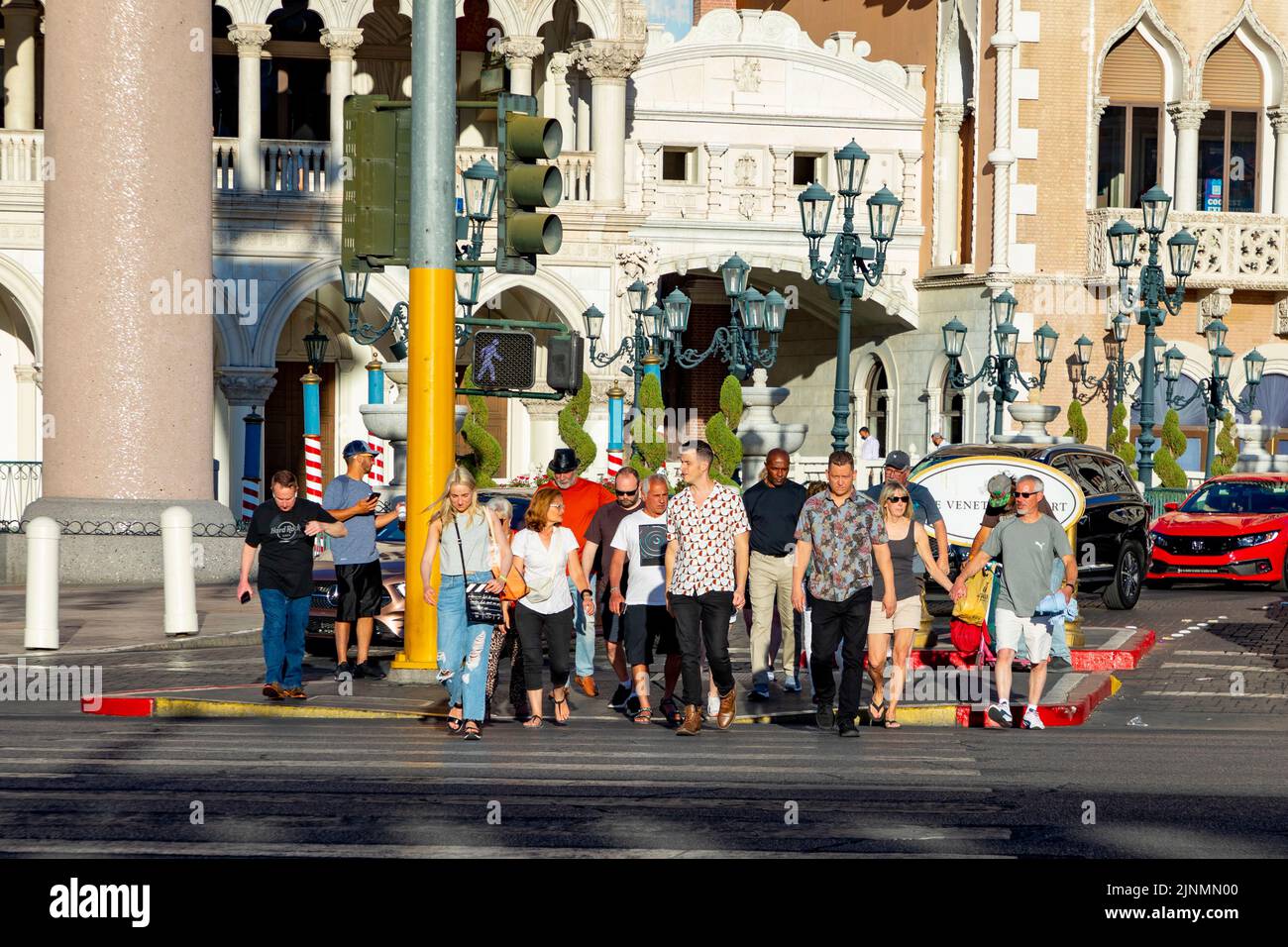 Las Vegas, EE.UU. - 24 de mayo de 2022: La gente en el cruce de peatones espera la luz verde. En el fondo Hotel The Venetian en el Strip durante el día. Foto de stock
