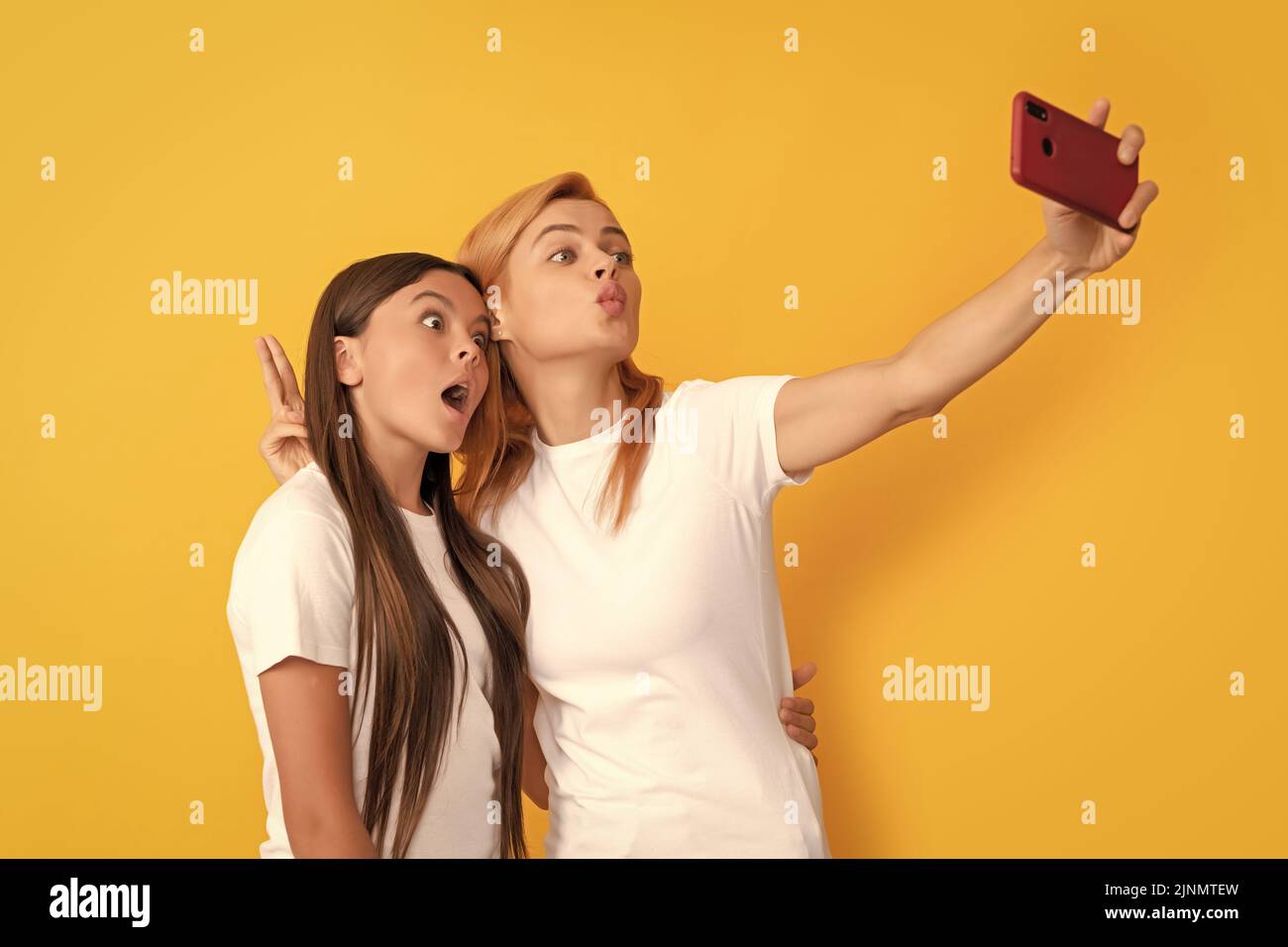 divertida madre e hija haciendo selfie en el smartphone, la red Foto de stock