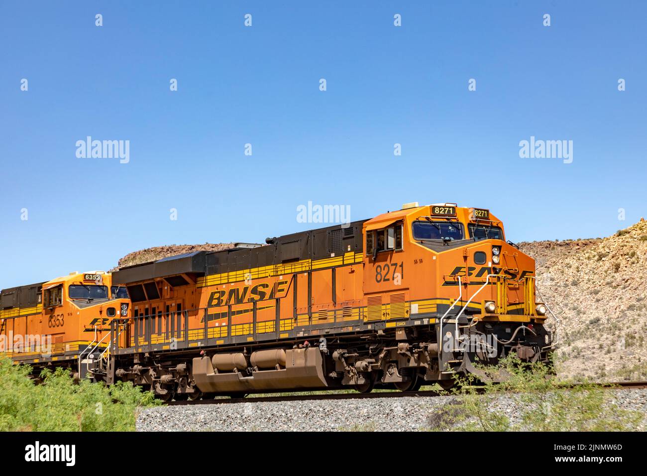 Valentine, EE.UU. 25 de mayo de 2022: El tren diesel con contenedor pasa por el paisaje desértico plano. Foto de stock