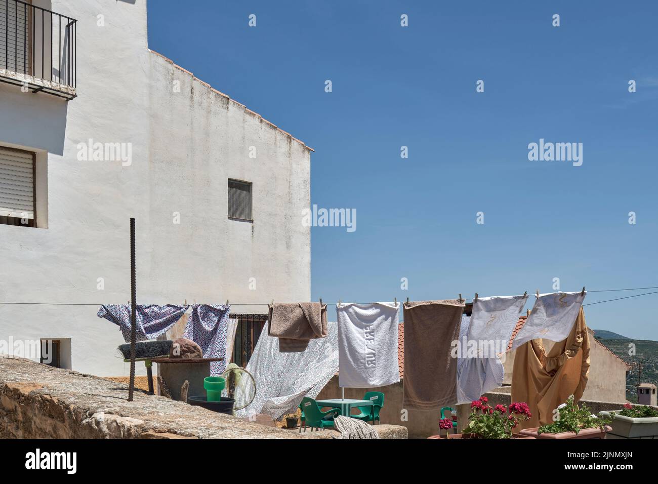 patio de una casa con ropa colgando sobre una cuerda secándose al sol en el pueblo de Culla, declarado el más bello de España, Castellón, España, Europa Foto de stock