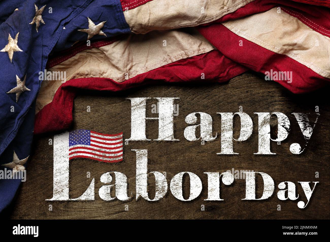 Bandera estadounidense sobre fondo negro gastado. Para la celebración del Día del Trabajo en EE.UU. Con texto Feliz Día del Trabajo. Foto de stock