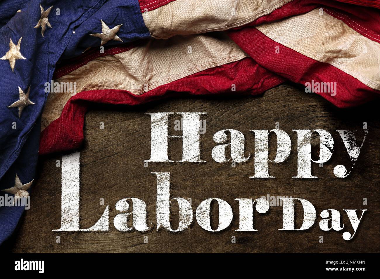 Bandera estadounidense sobre fondo negro gastado. Para la celebración del Día del Trabajo en EE.UU. Con texto Feliz Día del Trabajo. Foto de stock