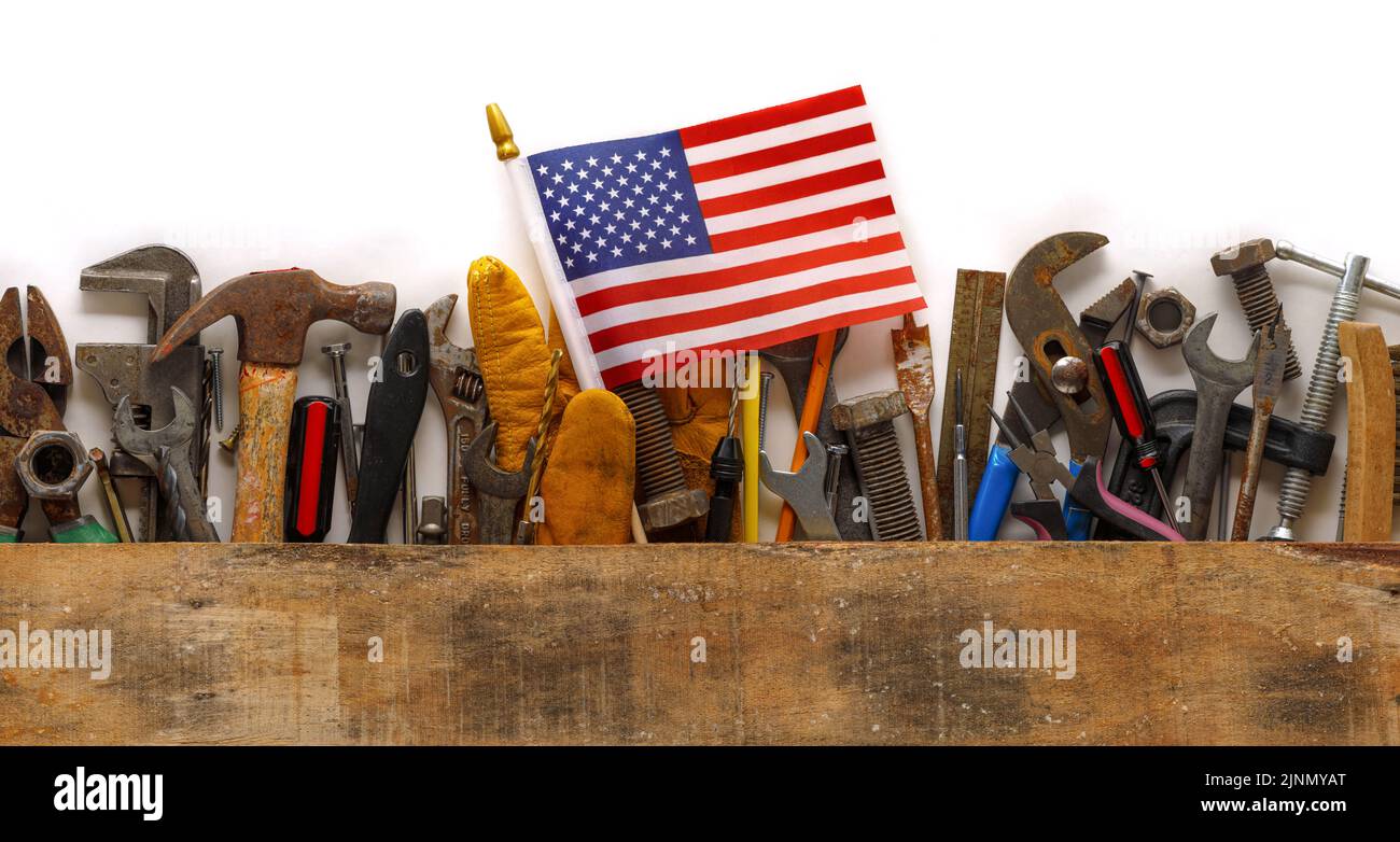 Colección patriótica de herramientas de trabajo usadas y usadas con pequeña bandera estadounidense. Hecho en EE.UU., fuerza laboral estadounidense o concepto de Día del Trabajo. Foto de stock